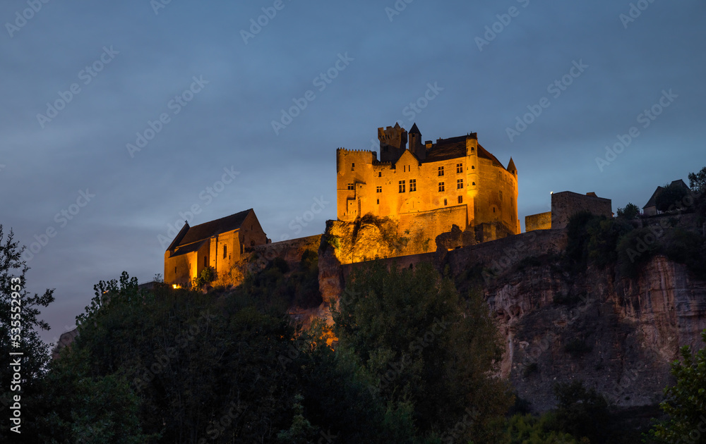 the illuminated castle of Beynac in the evening in the Dordogne area in France