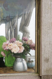 Vintage rose vase in the corner of the wooden window