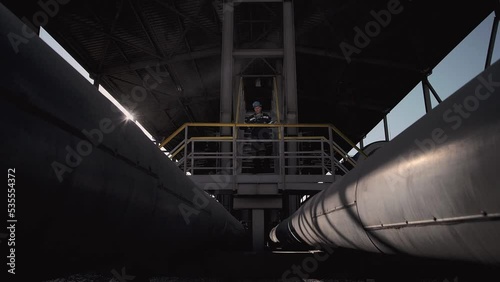 Gas worker walks down an iron ladder photo