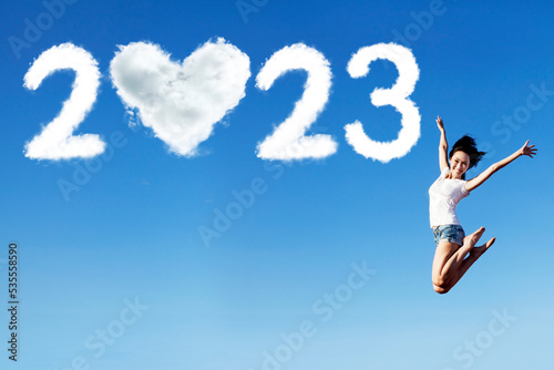 Woman jump with 2023 numbers and heart symbol