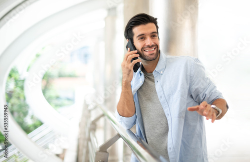 The businessman talking with ssmartphoneon their way. Feeling happy and relaxing, Casual young businessman wearing suit jacket.