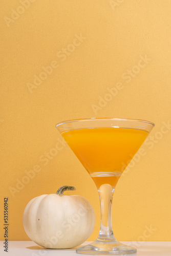 Halloween, Thanksgiving or fall cocktail pumpkintini cocktail. Sweet pumpkin martini, festive seasonal drink with cinnamon and pumpkin pie spices photo