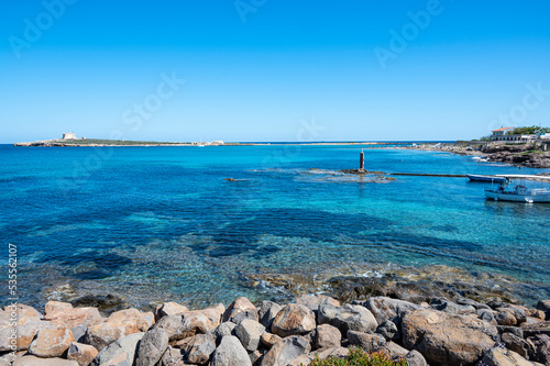 the beautiful sea of Portopalo with transparent and turquoise water with the island of Capo Passero in the background photo