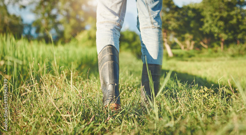 farmer wears boots walking on the ridge ,grass filed, farming concept, cultivation and agriculture