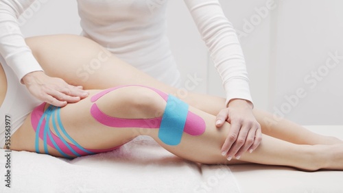 Therapist is applying tape to female body. Physiotherapy, kinesiology and recovery treatment.