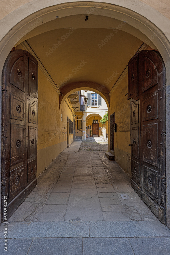 Fototapeta premium Picture along an old archway with pastel-coloured stone columns