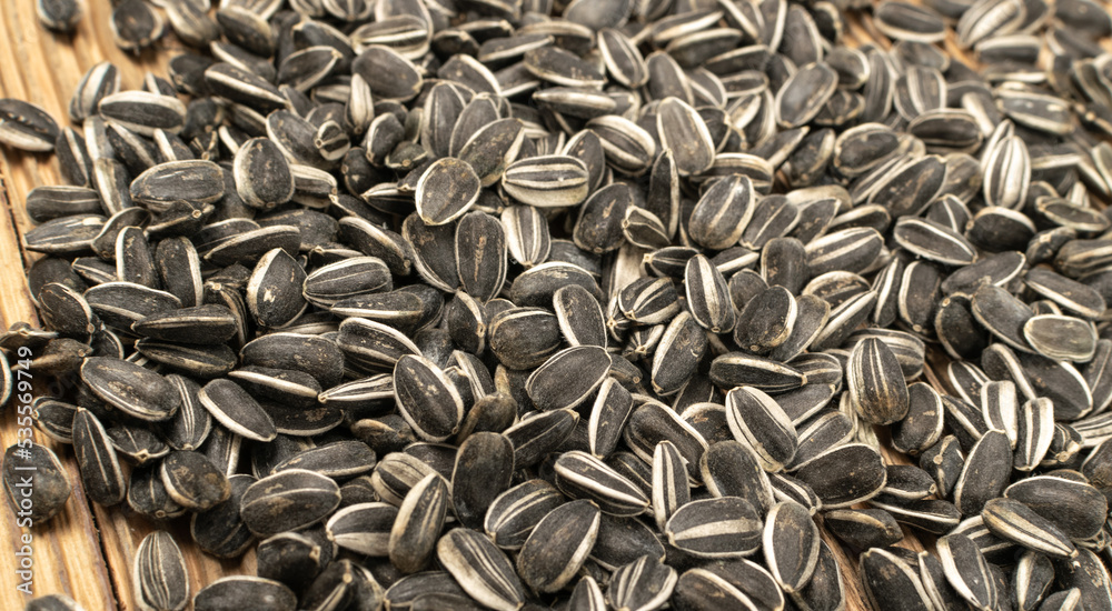 Sunflower Seeds, Striped Raw Seeds on Wood Background Texture Closeup