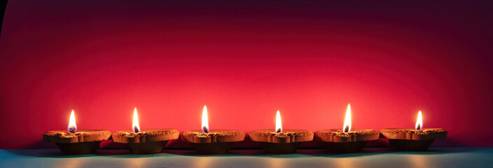 Diwali, Deepavali Hindu festival of lights. Diya lamp lit on red background