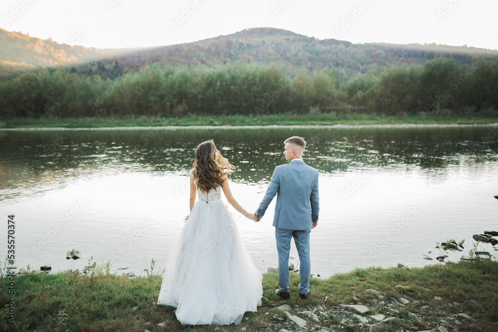 Wedding couple holding hands, groom and bride together on wedding day Wedding couple holding hands, groom and bride together on wedding day