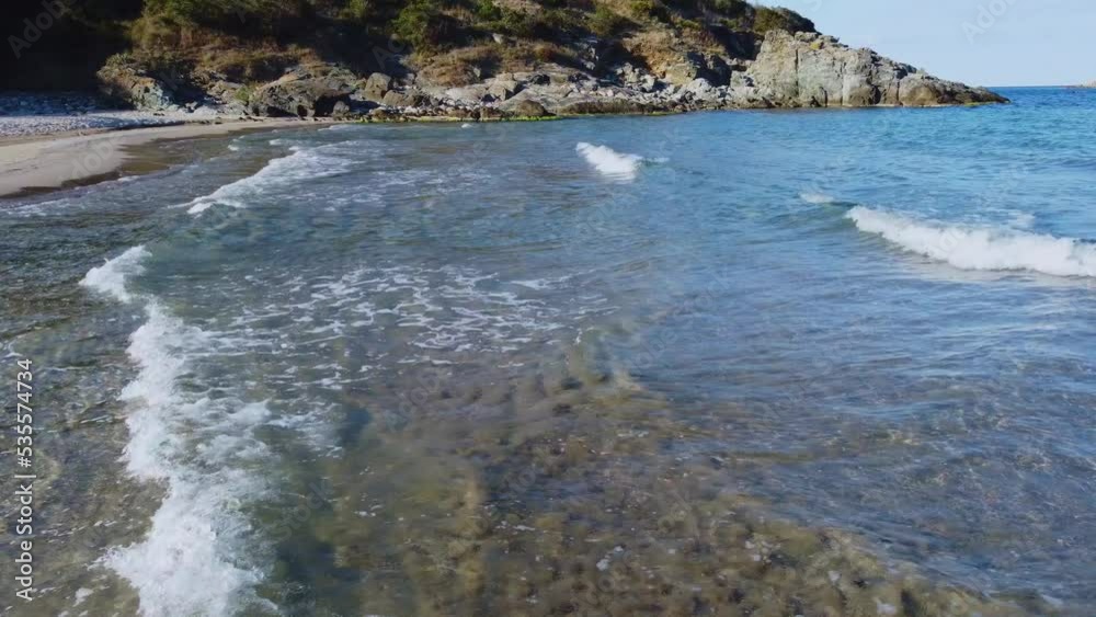Flying over the coastline with clear water and small waves. Flying over the coastline with clear water and small waves.
