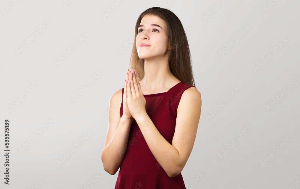 Hopeful woman in prayer pose on background Hopeful woman in prayer pose on background