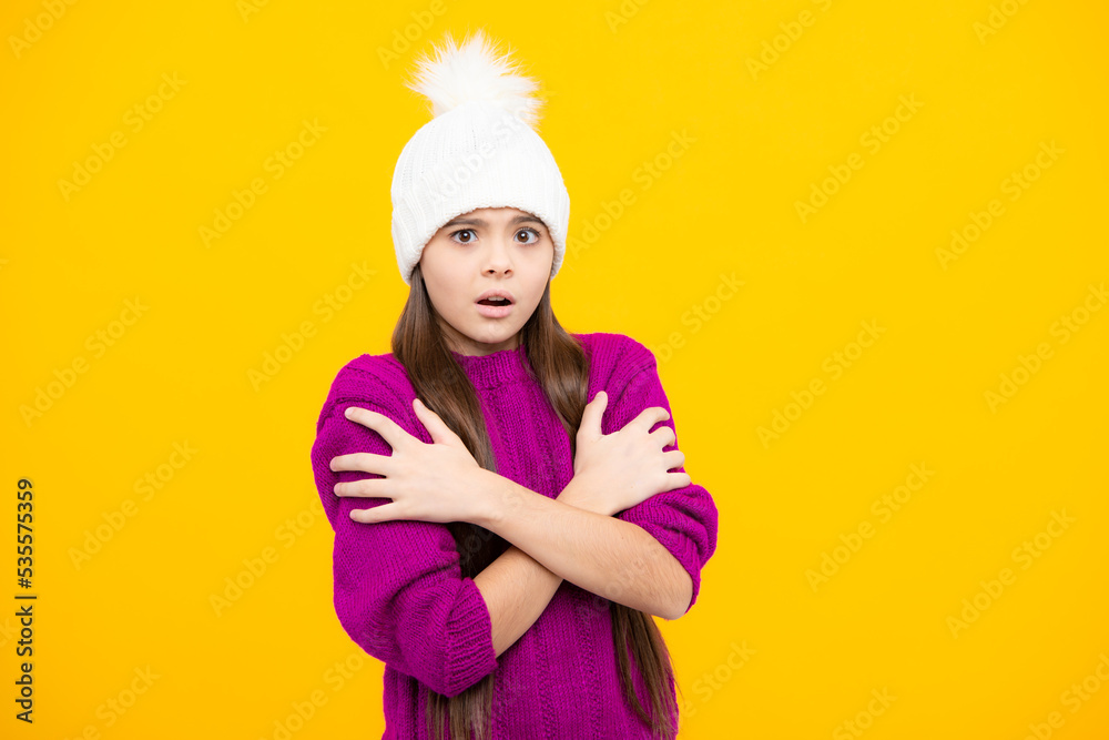 Modern teen girl wearing sweater and knitted hat on isolated yellow background. Angry teenager girl, upset and unhappy negative emotion.