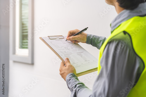 Building inspection, contractor asian young man, male inspecting home, reconstructed construction, renovation or check defect, before finish handing it over to client. Engineering worker, copy space.