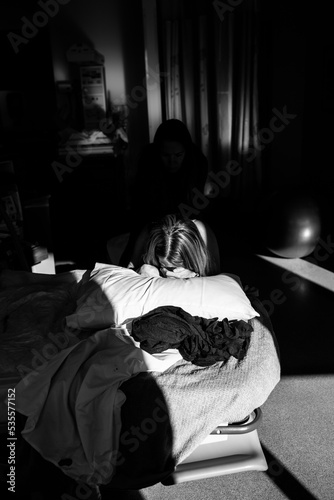Woman laboring on her knees in hospital overhead shot © Cavan