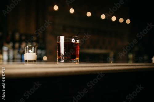 Votive candle and mixed drink sitting on the counter at a bar

 photo