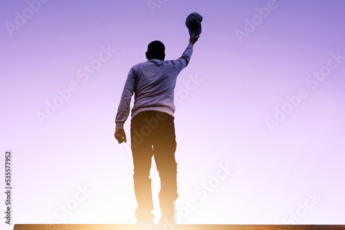 man portrait holding a cap and sunset background