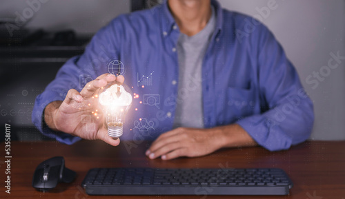 The hand of a businessman with a light bulb and there is a cloud computing icon in it with diagram show on hand. Cloud technology. Data storage. Networking and internet service concept.