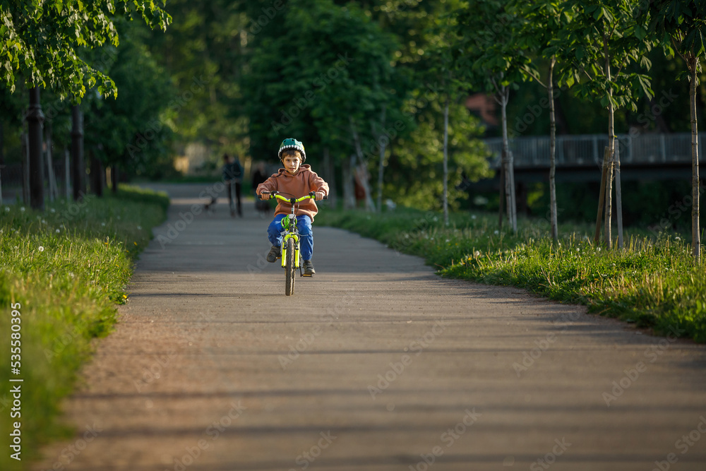 Obraz premium Boy learning to ride bike. Child travels through urban alley