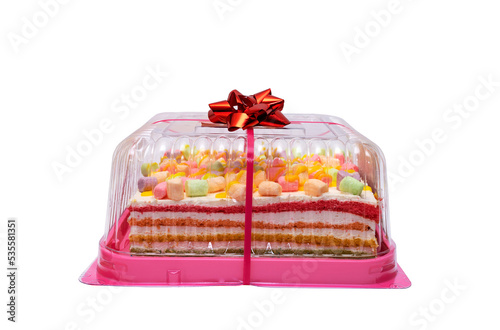 multi-colored rainbow cake in a transparent box with a red bow. Celebration cake isolated on a white background.