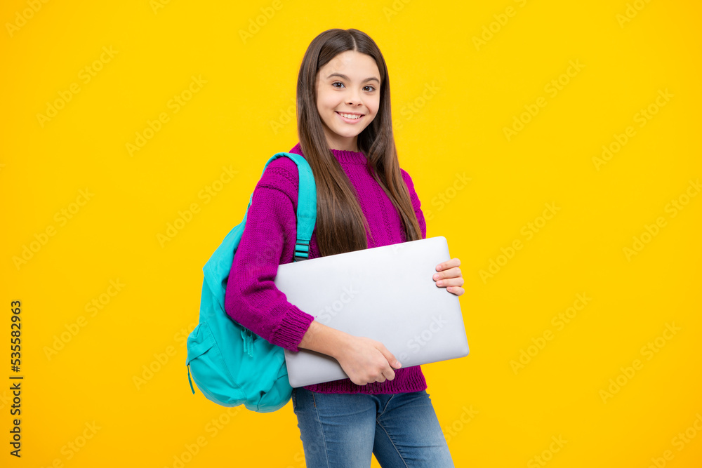 Fototapeta premium Teen schoolgirl hold laptop on isolated studio background. Cchool student learning online, webinar, video lesson, distance education.