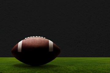 American Football ball on green field at the stadium