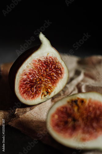 Fig cut in half on parchment, black background