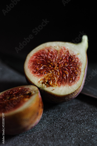 Fig cut in half on parchment, black background