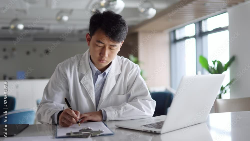 young man doctor works with laptop in office young man doctor works with laptop in office