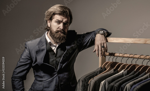 Male suits hanging in a row. Men clothing, boutiques. Man suit, tailor in his. Tailor, tailoring photo