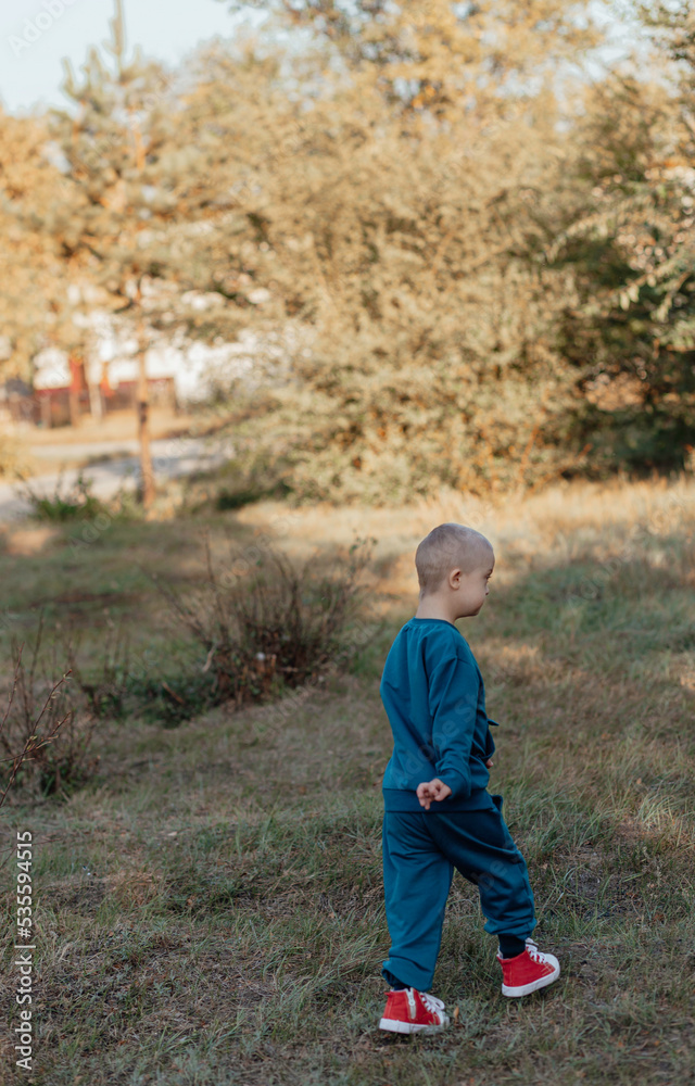 boy with Down syndrome runs walk, a disabled child boy with Down syndrome runs walk, a disabled child