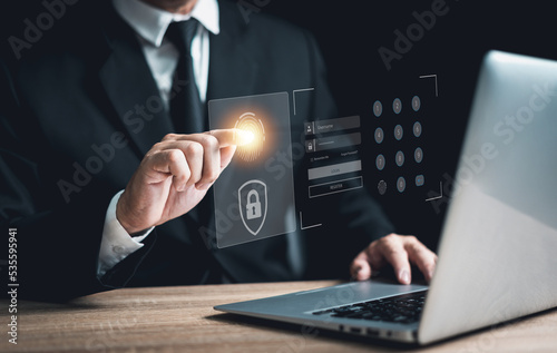 Businessman scans fingerprint on the virtual screen to access the laptop. Concept of internet security, data protection, blockchain, and cybersecurity.