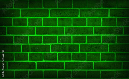 Neon light on an old brick wall. toxic green grunge background. Light effect