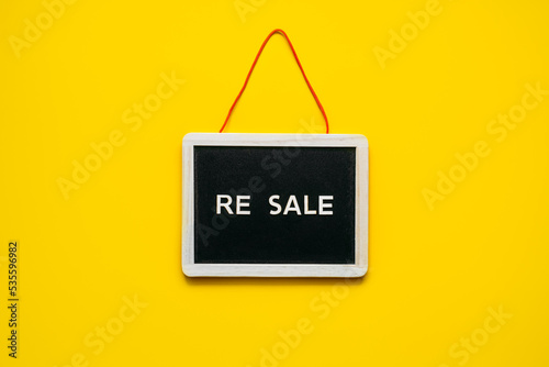 Resale-commerce, re-commerce, re sale concept. Buyback, Trade-In, and Upcycling in Retail. Circular economy. Word resale and clothing on yellow background