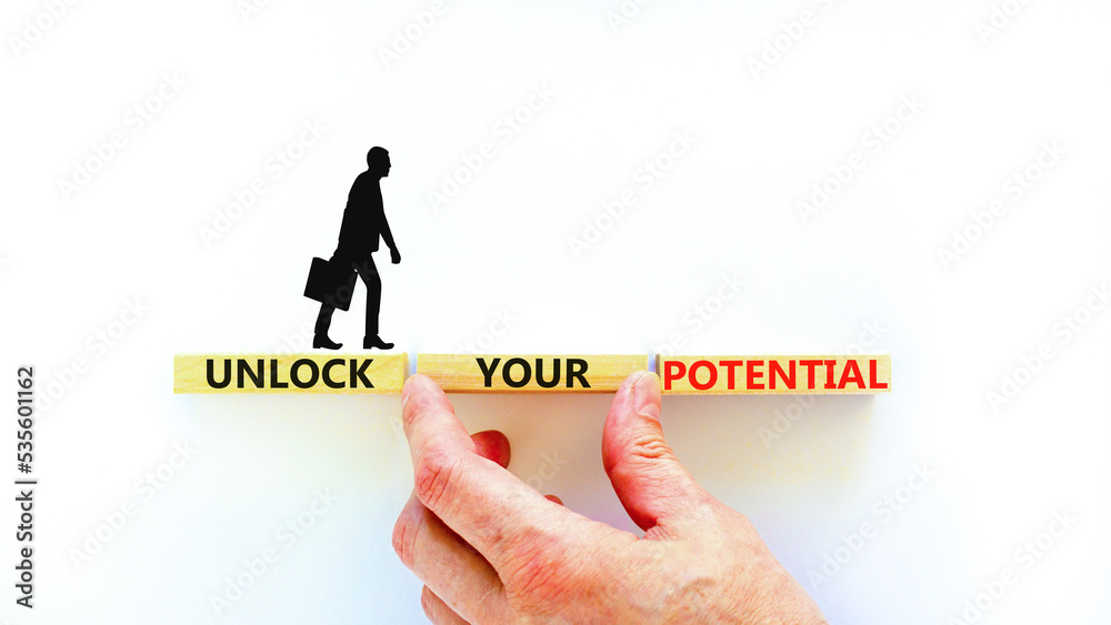 Unlock your potential symbol. Concept words Unlock your potential on wooden blocks. Businessman hand. Beautiful white background. Business, psychological unlock your potential concept. Copy space. Unlock your potential symbol. Concept words Unlock your potential on wooden blocks. Businessman hand. Beautiful white background. Business, psychological unlock your potential concept. Copy space.