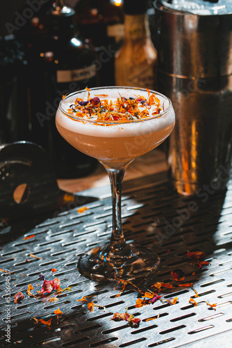Fall cocktail garnished with edible flowers on the rim of the glass