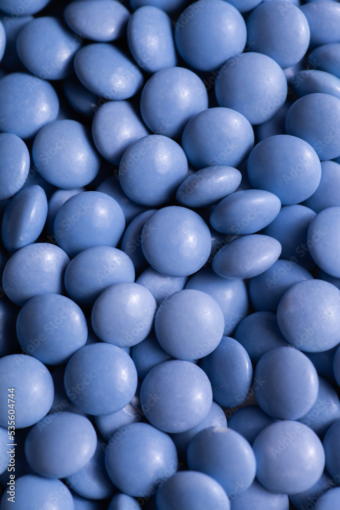 Close up of blue candy coated chocolate button sprinkle texture - M&Ms, Smarties, sprinkles Close up of blue candy coated chocolate button sprinkle texture - M&Ms, Smarties, sprinkles