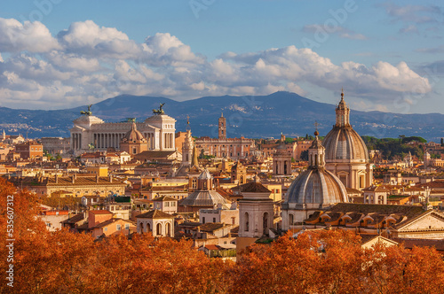 Autumn in Rome. View of the Eternal City historical center old skyline with autumnal red leaves photo