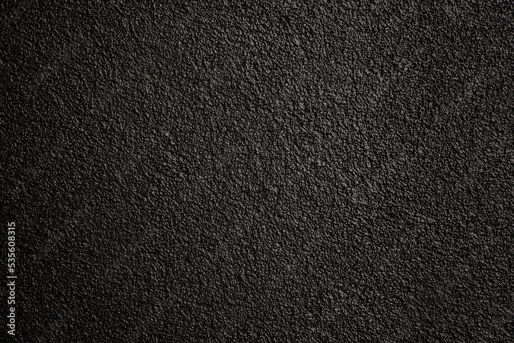 Black or dark gray rough grainy stone or sand texture background