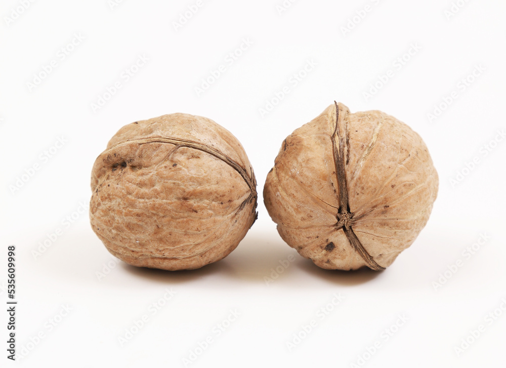 Unpeeled walnuts on a white background. Close-up Unpeeled walnuts on a white background. Close-up