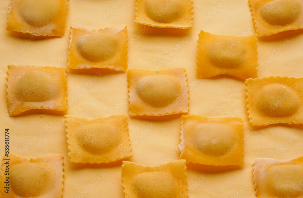 Pattern, raw pasta with filling on a yellow background. Ingredients for dinner