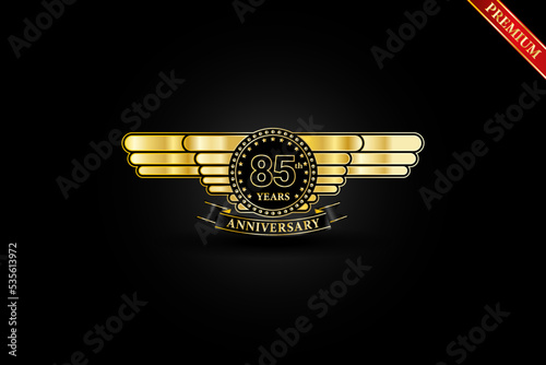 85th anniversary golden wing gold logo with gold ring and ribbon isolated on black background, vector design for celebration.