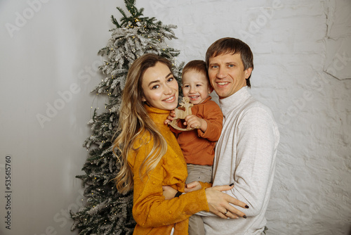 Mom, dad and son on the background of the Christmas tree at home