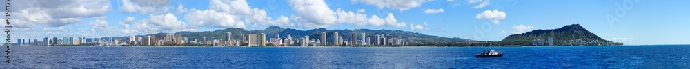 Wide panoramic view of Honolulu as seen from a boat off Waikiki in Hawaii - Modern American city skyline on the O'ahu volcanic island in the middle of the Pacific Ocean