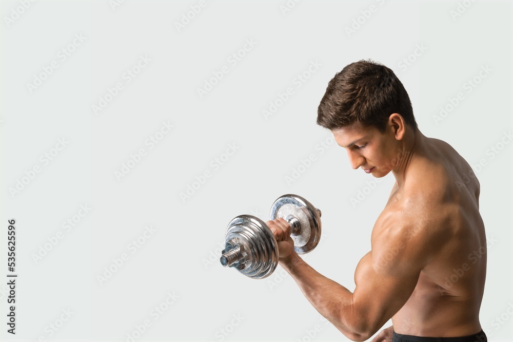Handsome young man exercising with dumbbells Handsome young man exercising with dumbbells