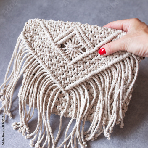 Handmade macrame cotton сross-body bag. Eco bag for women from cotton rope. Scandinavian style bag.  Bejge tones, sustainable fashion accessories. Details. Close up image photo