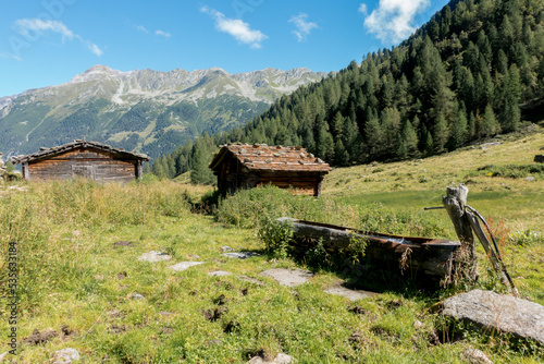 Holzhütte mit Schindeldach und Brunnen aus Holz photo