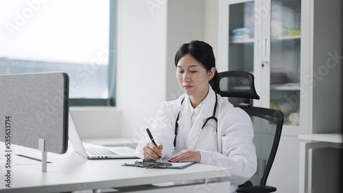 Wallpaper Mural young woman doctor works with clipboard in clinic Torontodigital.ca