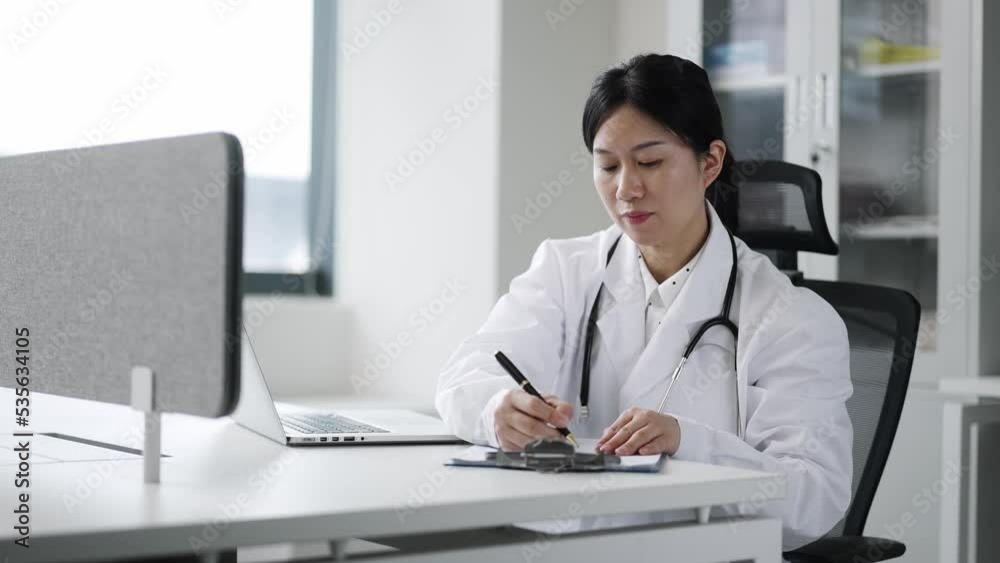 young woman doctor works with clipboard in clinic young woman doctor works with clipboard in clinic