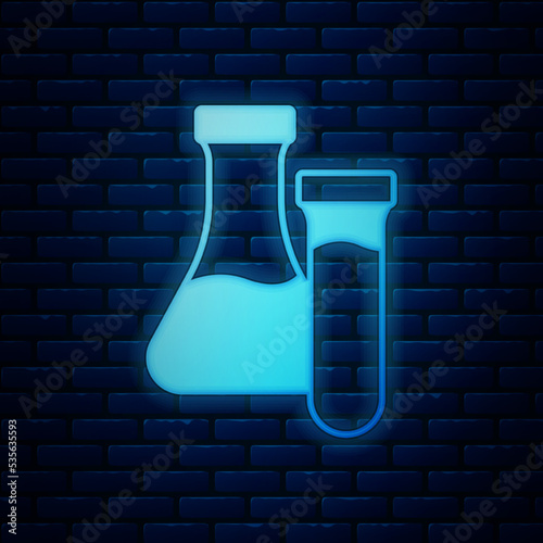Glowing neon Test tube and flask chemical laboratory test icon isolated on brick wall background. Laboratory glassware sign. Vector