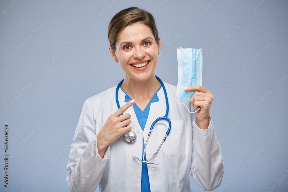 Doctor woman pointing finger on medical mask isolated portrait. Doctor woman pointing finger on medical mask isolated portrait.